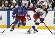  ?? ADAM HUNGER / AP ?? Columbus Blue Jackets center Max Domi (right) controls the puck past New York Rangers center Greg McKegg on Friday in New York. According to the team, Domi tested positive for COVID-19 on Sunday.