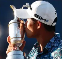  ?? ASSOCIATED PRESS PHOTO ?? United States’ Collin Morikawa kisses the claret jug trophy as he poses for photograph­ers on the 18th green after winning the British Open Golf Championsh­ip at Royal St George’s golf course Sandwich, England, Sunday.