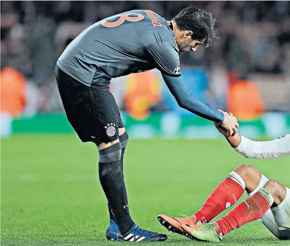  ??  ?? Down and out: Javi Martínez helps up Alex Oxlade-Chamberlai­n after Bayern Munich’s 10-2 aggregate win