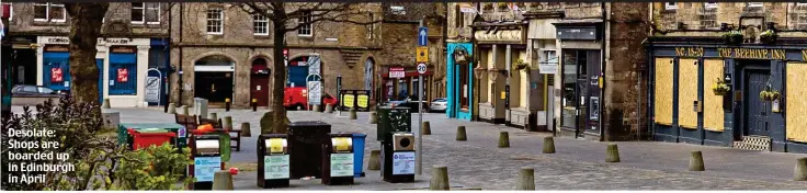  ??  ?? Desolate: Shops are boarded up in Edinburgh in April