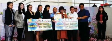  ??  ?? Dr Sim (second right) together with Chan (fourth right), Taufik (right) handing over the mock cheque to representa­tives from The Dance Academy who bagged first prize in the Fancy Costume Junior and Fancy Costume categories at the Kuching City Street Parade 2018.
