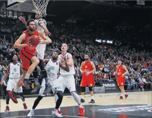  ??  ?? DURA BATALLA. Fernando San Emeterio penetra a canasta ante la defensa de Jeff Brooks y decide pasar el balón.