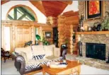  ??  ?? A dry-stacked stone   replace and exposed timbers add rustic elegance to the living room.