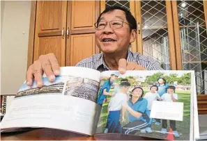  ?? — YAP CHEE HONG/ The Star ?? Dr Fong taking us through his book ( cover pictured right) and some of his favourite shots. This one is of a teacher and student playing a game of passing a rubber band with a straw during the school’s open day.