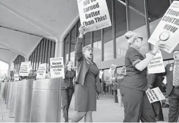  ?? New York Times file ?? United Airlines flight attendants picket at Newark Liberty Internatio­nal in Newark, N.J., this month. More than five years after United and Continenta­l merged, the air carriers’ attendants are still operating as if the merger never happened. That will...