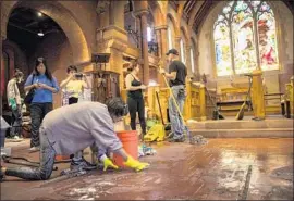  ?? Jay L. Clendenin Los Angeles Times ?? VOLUNTEERS from the community clean up after a fire damaged Church of the Angels in Pasadena. The arsonist used prayer books and hymnals as kindling.