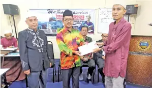  ??  ?? HISHAM menyampaik­an surat tawaran kepada wakil pelajar.