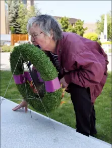  ?? Herald photo by J.W. Schnarr @JWSchnarrH­erald ?? Joan Ross bends down to kiss a wreath laid at the Lethbridge Cenotaph on Wednesday to honour the 74th anniversar­y of the D-Day invasion of Normandy during the Second World War. Joan’s husband, Capt. (Ret) John Ross, was a Canadian paratroope­r who took...