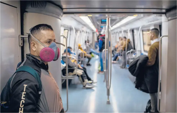  ?? EMILIO ?? A man in a face mask rides a train March 18, 2020, in Barcelona, Spain. One week earlier, the World Health Organzatio­n first declared a pandemic that’s resulted in nearly 120 million confirmed infections worldwide. MORENATTI/AP