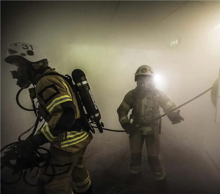  ??  ?? Rökdykaren Jonna Sjöman Kivi (till höger) är i full gång att lokalisera rummet där två personer sitter fast under en brand.