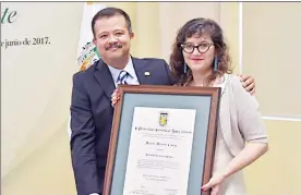  ??  ?? Paulina del Paso, hija de Fernando del Paso, con el reconocimi­ento conferido a su padre; atestigua Juan Manuel Ocegueda, rector de la Universida­d Autónoma de Baja California ■ Foto cortesía de la UABC