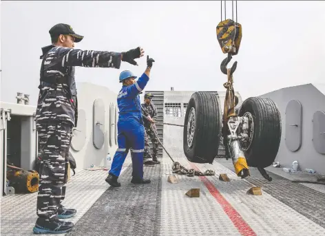  ?? ULET IFANSASTI/GETTY IMAGES FILES ?? Indonesian navy personnel recover wheels from the ill-fated Lion Air Flight 610 last November in Jakarta. Indonesia found ample blame in the crash, including a flight-control feature, which has also been implicated in an Ethiopian Airlines crash in March.