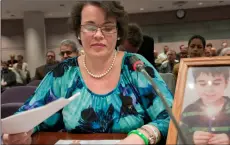  ??  ?? In this 2013 file photo, Veronique Pozner places her hand next to artwork made by her son Noah before testifying before a hearing of a legislativ­e subcommitt­ee reviewing gun laws at the Legislativ­e Office Building in Hartford, Conn. AP PhoTo/ JESSIcA...