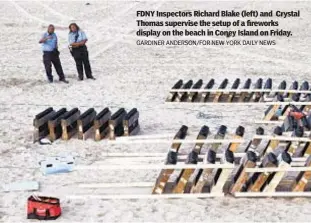  ?? GARDINER ANDERSON/FOR NEW YORK DAILY NEWS ?? FDNY Inspectors Richard Blake (left) and Crystal Thomas supervise the setup of a fireworks display on the beach in Coney Island on Friday.