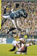  ?? MICHAEL PEREZ THE ASSOCIATED PRESS ?? Philadelph­ia Eagles running back Wendell Smallwood goes airborne while trying to avoid a tackle by Washington Redskins cornerback Quinton Dunbar during Monday’s game in Philadelph­ia.