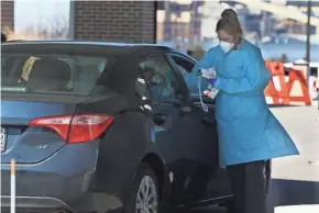  ?? ANGELA PETERSON / MILWAUKEE JOURNAL SENTINEL ?? A medical worker takes the temperatur­e of a patient using the drive-through coronaviru­s testing area at Froedtert & the Medical College of Wisconsin in Pleasant Prairie on Tuesday.