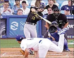  ?? MARK J. TERRILL / AP ?? The Pirates’ Bryan Reynolds hits a two-run home run as Dodgers starting pitcher Mitch White watches along with catcher Austin Barnes and home plate umpire Chad Fairchild during the fifth inning Wednesday