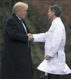  ?? Saul Loeb/AFP/Getty Images ?? President Donald Trump shakes hands in January with the White House physician, Dr. Ronny Jackson, at Walter Reed National Military Medical Center in Bethesda, Md.