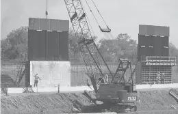  ?? ERIC GAY/AP ?? Constructi­on workers build a section of the border wall separating the U.S. from Mexico on Nov. 16 in Mission, Texas.