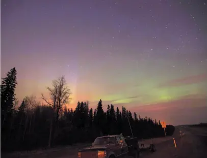  ?? CP FILE PHOTO ?? The northern lights shine above the glow from a wildfire on highway 63 south of Fort McMurray, Alta., on May 6, 2016. New online maps lets viewers zero in on how climate change will affect Canada’s boreal forest where they live.