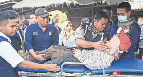  ??  ?? Un equipo de rescate da tratamient­o a una persona que quedó atrapada en el monte Rinjani, en Sembalun, Lombok Timur, Indonesia.