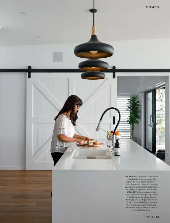  ??  ?? THIS PAGE The view from the kitchen island is straight out to sea; the lights are from Lighting Direct – Belinda wanted black for contrast and enjoys their timber detailing to suit other aspects of the kitchen. OPPOSITE The hippo was a musthave purchase during a trip to Bali; Belinda chose the glossy double herringbon­e tiled splashback for impact; the wide hallway leads to the bedrooms, bathrooms and entrance, and the barn door to a second living area.