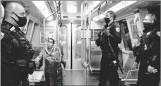  ?? JESSICA CHRISTIAN/SAN FRANCISCO CHRONICLE VIA AP ?? San Francisco Bay Area Rapid Transit police officers Nick Luzano (left) Eric Kelly, center, and Eric Hofstein (right) wear masks while patrolling a Richmond bound train from Powell Street Station BART platform in San Francisco, Calif., in 2020.