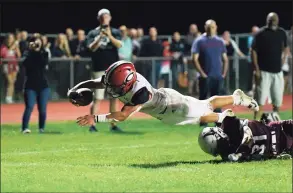  ?? David G. Whitham / For Hearst Connecticu­t Media ?? Cheshire running back Christian Russo dives into the end zone for his second touchdown of the night against North Haven earlier this season.