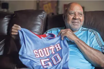  ?? SEAN LOGAN/THE REPUBLIC ?? Longtime South Mountain coach Richard Thompson on July 15 holds a South Mountain basketball jersey with his late son Tyrice's No. 50 on it.