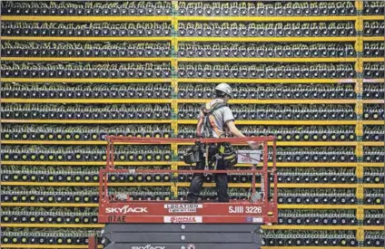  ?? Photo: Lars Hagberg/afp ?? Possibilit­ies: A technician inspects the backside of bitcoin mining in Quebec, Canada. The South African Reserve Bank would find the technology beneficial in a number of ways.