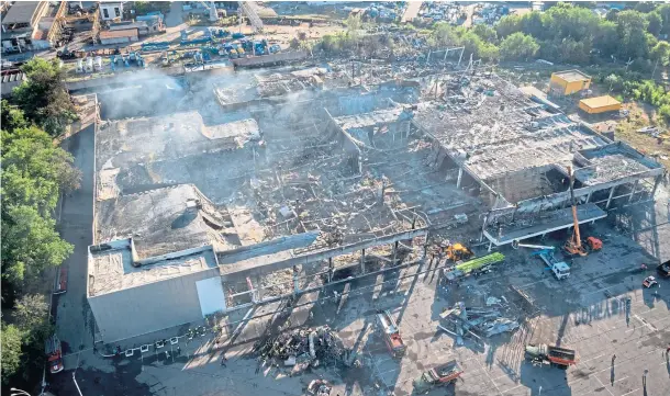  ?? ?? DESTROYED: Ukrainian firefighte­rs work to take away debris at a shopping centre burned after a Russian rocket attack in Kremenchuk.