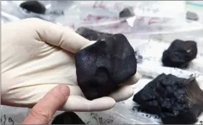  ?? The Canadian Press ?? University of Calgary planetary scientist Dr. Alan Hildebrand holds a meteorite fragment recovered near Lloydminst­er on the Alberta-Saskatchew­an border in a file photo.