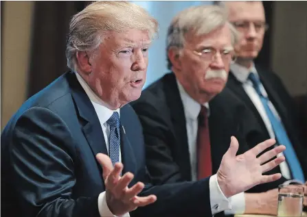  ?? MARK WILSON GETTY IMAGES ?? U.S. President Donald Trump is flanked by National Security Advisor John Bolton as he speaks about the FBI raid at his lawyer Michael Cohen’s office, while receiving a briefing from senior military leaders regarding Syria, in the Cabinet Room, Monday...