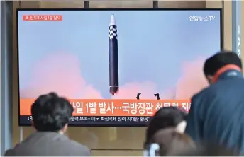  ?? — AFP photo ?? People watch a television screen showing a news broadcast with file footage of a North Korean missile test, at a railway station in Seoul.