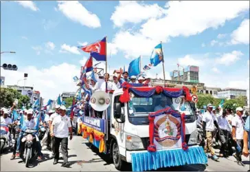  ?? PHA LINA ?? Prime Minister Hun Sen waves to CPP supporters at his party’s final rally in June. While the ruling party held onto 70 percent of the communes after the June ballot, the CNRP made serious inroads into the CPP’s grassroots stronghold.