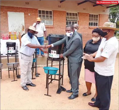  ??  ?? Pic: Praisemore Sithole
FROM LEFT: Africa Ahead executive director Regis Matimati handing over handwashin­g stations to Bulawayo ward 22 councillor Rodney Jele, who was representi­ng mayor Solomon Mguni on Thursday at Queen Elizabeth Primary School