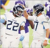  ?? Bruce Kluckhohn / Associated Press ?? The Titans’ Derrick Henry (22) celebrates with Ryan Tannehill, right, after scoring against the Vikings last month. The Titans’ game with the Bills on Sunday could be in jeopardy as Tennessee continues to struggle to contain a coronaviru­s outbreak among the team.