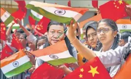  ?? PTI ?? Students wave the flags of China and India in Chennai on Thursday ahead of Chinese President Xi Jinping's visit to the city on Friday.