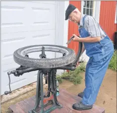  ?? KIRK STARRATT ?? John Eaton of Somerset works with his antique tire changer.