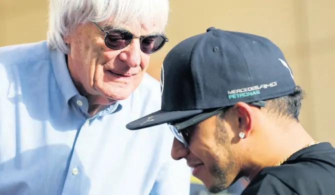  ??  ?? FILE In this Thursday, April 16, 2015 file photo, Bernie Ecclestone (left), president and CEO of Formula One Management, talks to Mercedes driver Lewis Hamilton ahead of the Bahrain Formula One Grand Prix at the Formula One Bahrain Internatio­nal Circuit in Sakhir, Bahrain.