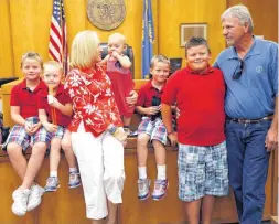  ??  ?? Above: The Mathes family poses for photos after adopting their grandchild, Kyleigh. From left to right, Brent, Nathan, Cathy, Kyleigh, Bryce, Blake and Stephen.