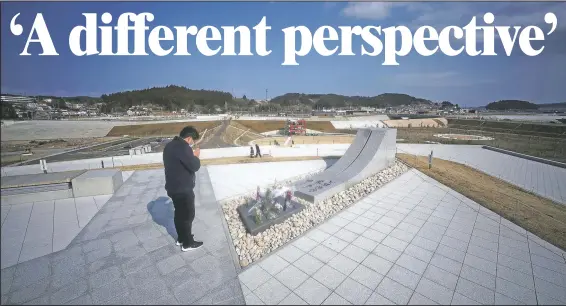  ?? (AP/Eugene Hoshiko) ?? A visitor prays Saturday for victims at a memorial park near former local Disaster Prevention Center where 43 workers died and ruined by the 2011 earthquake and tsunami in Minamisanr­iku, Japan.