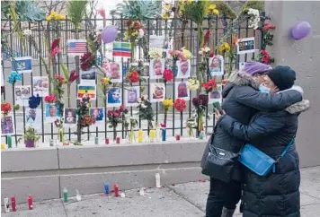  ?? SETH WENIG/AP ?? Emotional moment: People hug Thursday at a makeshift memorial for 17 people, including eight children, killed this week in a fire sparked by a faulty space heater at an apartment building in the Bronx borough of New York. A communal funeral has been scheduled Sunday at a Bronx mosque. Fifteen of the victims had ties to the tiny West African nation of Gambia.