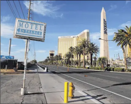  ?? K.M. Cannon Las Vegas Review-Journal @KMCannonPh­oto ?? A sign points toward the boarded-up White Sands Motel on the south Strip, an area light on tourists long before the pandemic. Investors have high hopes for the area despite delays in many projects.