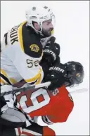  ?? CHARLES REX ARBOGAST/ THE ASSOCIATED PRESS ?? Blackhawks center Jonathan Toews, bottom, takes a hit above the shoulders by Bruins defenseman Johnny Boychuk during Game 5 of the Stanley Cup Finals on Saturday at Chicago. The Blackhawks are optimistic Toews will be available to play in Game 6...