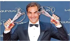  ?? FOTO: YE PINGFAN/XINHUA/DPA ?? Tennis-Star Roger Federer zeigt seine Auszeichnu­ngen, den Award als Sportler des Jahres und die Ehrung für das Comeback des Jahres.