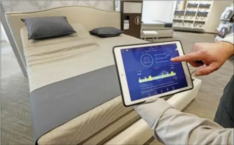  ?? ROGELIO V. SOLIS — THE ASSOCIATED PRESS ?? In this Friday photo, Sleep Number store manager Lee Pulliam demonstrat­es how the company’s sleep technology tracks your sleeping patterns, in addition to the other features of the Sleep Number 360 Smart Bed, including a foot warming element,...