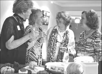  ?? Photos by F & E Schmidt ?? Above, from left, Beverly Sullivan, Peggy Ralph, Ruthie Windsor-Mann and Mary Ann Kuhn enjoy a chat and the feast at the Catstravag­anza. Inset: John Sullivan, assisted by young friend, auctions donated items at the fundraiser.