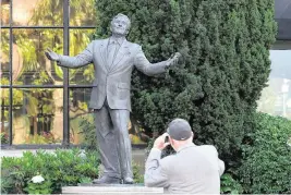  ?? JUSTIN SULLIVAN Getty Images/TNS, file ?? A pedestrian stops to take a picture of a Tony Bennett statue at the Fairmont Hotel on July 21, 2023, in San Francisco.