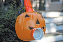  ??  ?? A jack-o-lantern adorns the end of a candy chute for trick-or-treaters made by Liam Ford, a Chicago Tribune editor. The tube delivers Halloween candy without contact.